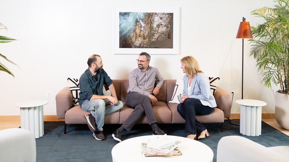Muammer Akgün, Erhan Musaoglu and Elizabeth Walsh talking on a couch in Logiwa's Chicago office