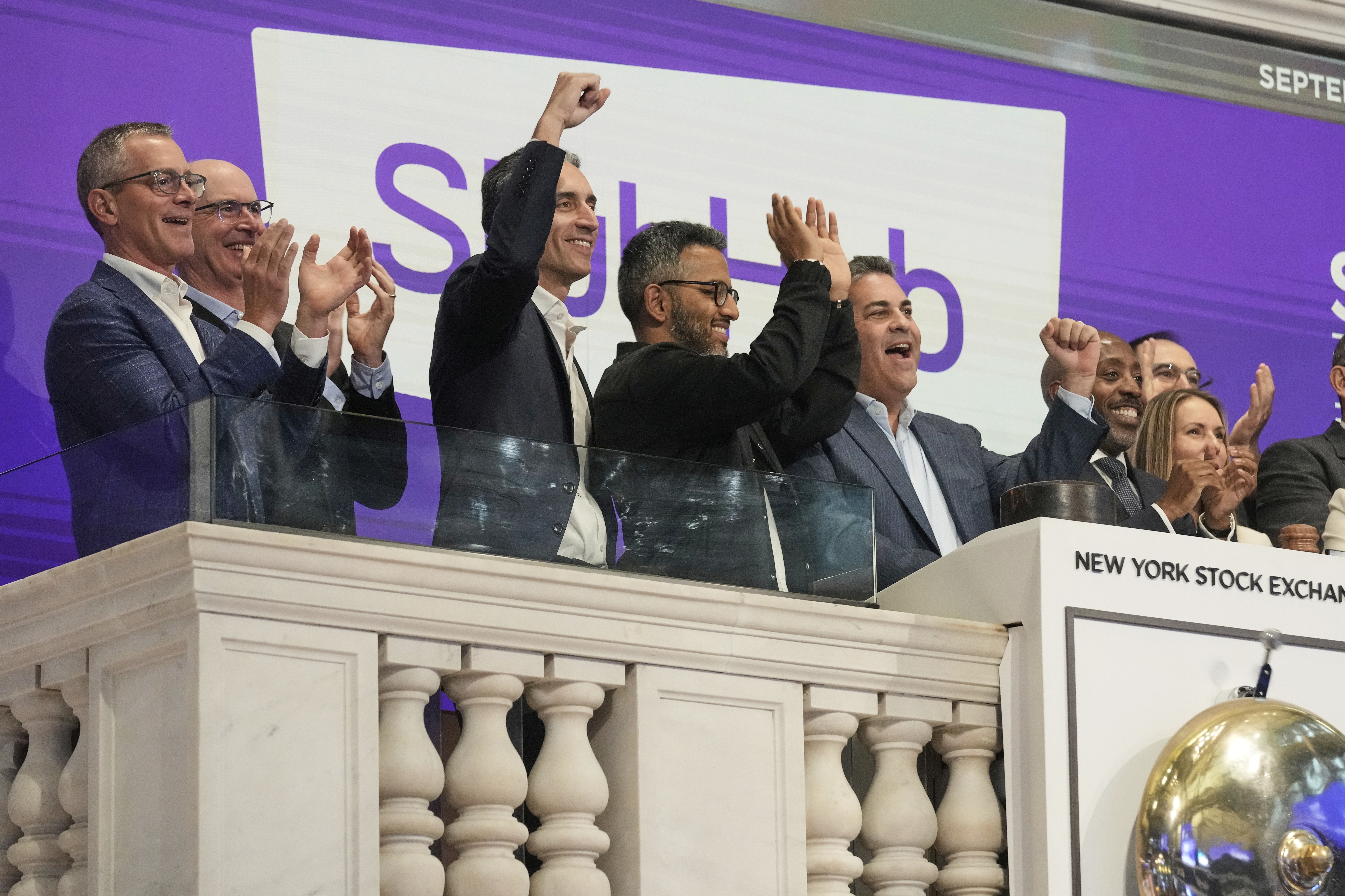 Eric Baker raises his fist alongside StubHub colleagues celebrating at the New York Stock Exchange opening bell.
