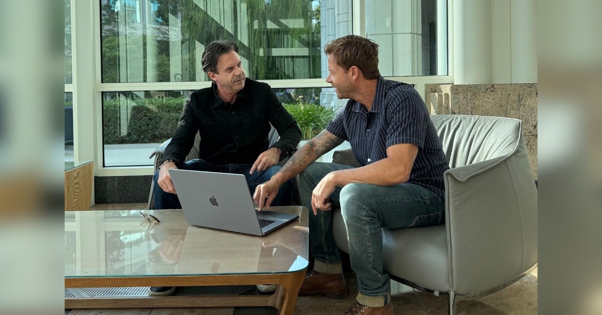 Branden Chambers seated on the left and Eric Chambers on the right beside an open laptop