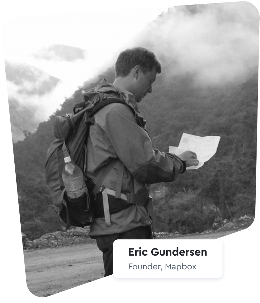 Eric Gundersen outdoors with a backpack, looking at a paper map