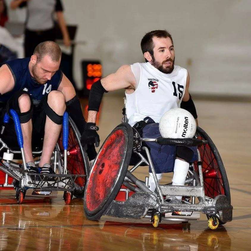 Eric Ingram wearing number 15 and carrying the ball during a wheelchair rugby game
