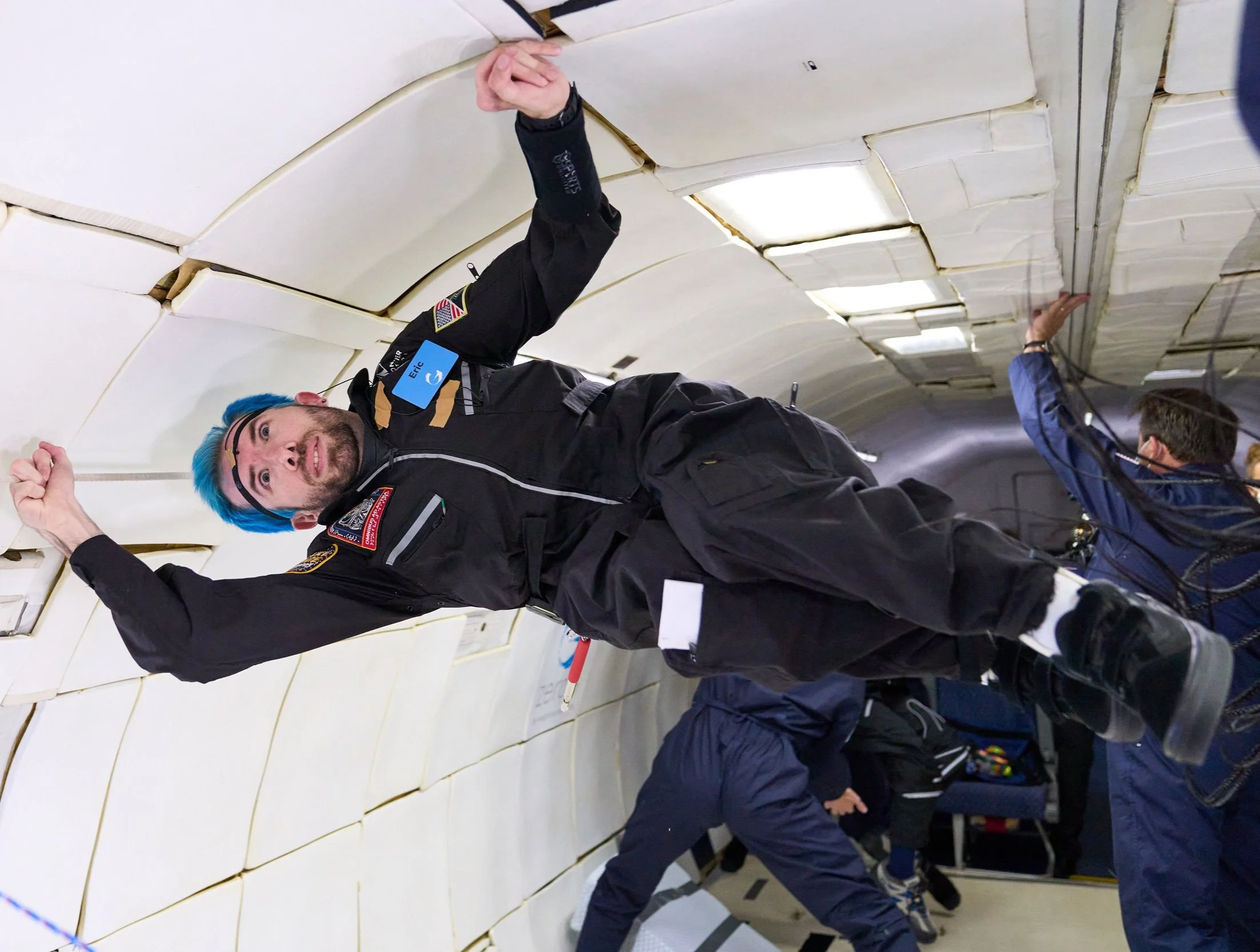 Eric Ingram floating horizontally inside a padded zero-gravity aircraft cabin
