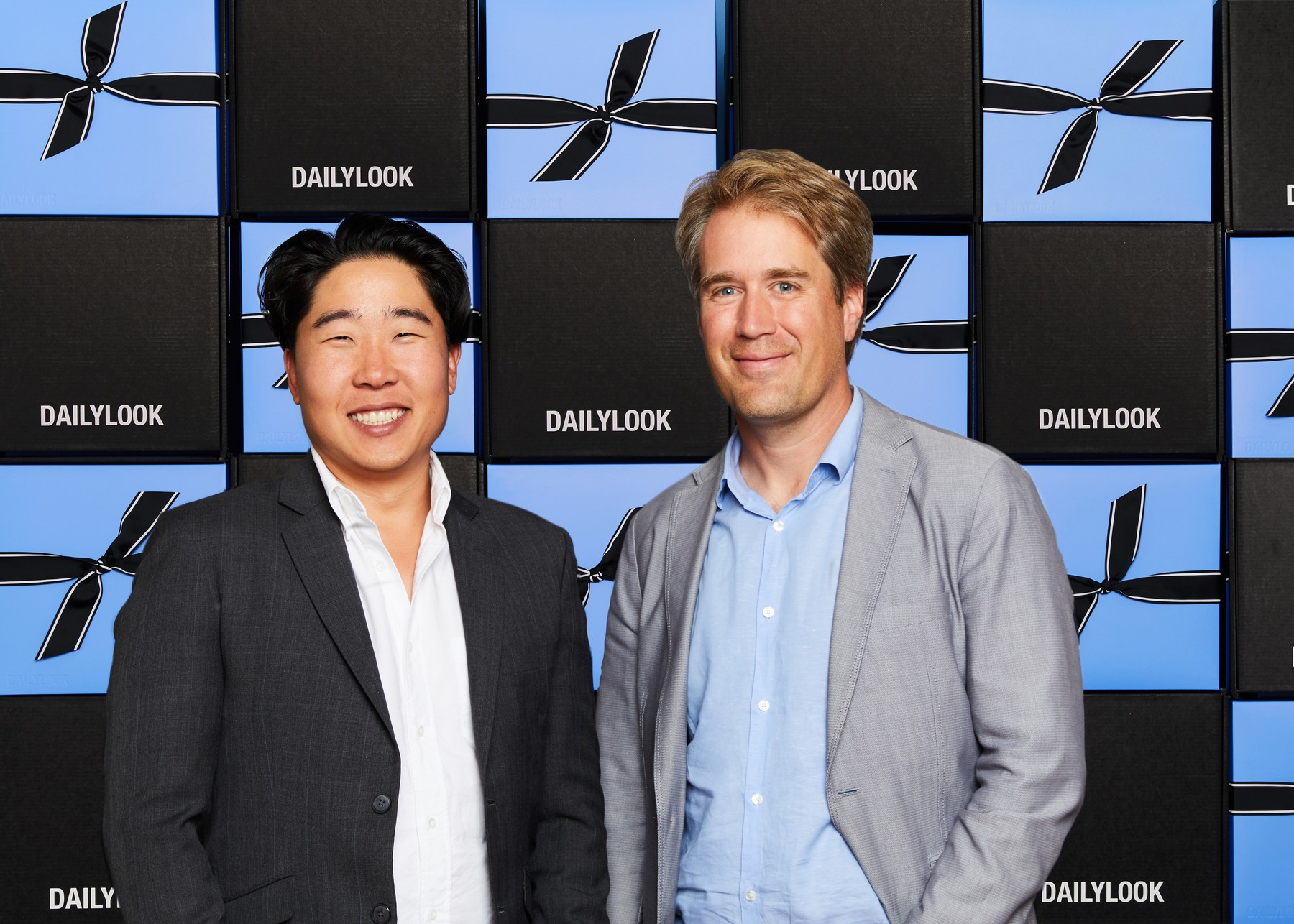 DAILYLOOK co-founders Brian Ree and Eric Marston standing before a wall of branded gift boxes