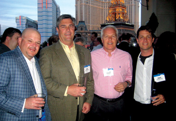 Archival group photograph of Phil Lalonde with Eric Mathewson, Bruce Roberts and Mike Zinsmeister at WideOrbit’s 2012 NAB gathering.