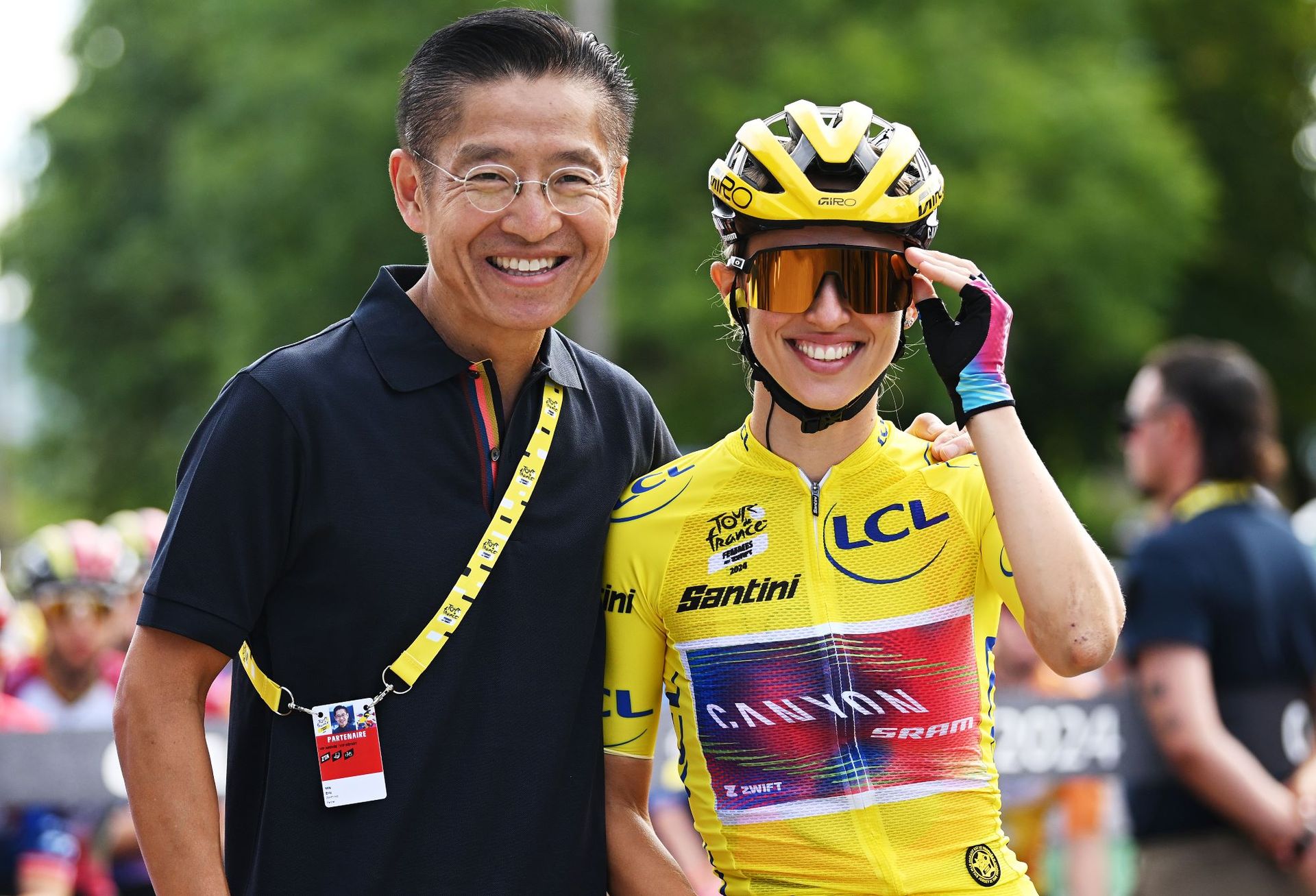 Eric Min standing beside cyclist Kasia Niewiadoma at the Tour de France Femmes