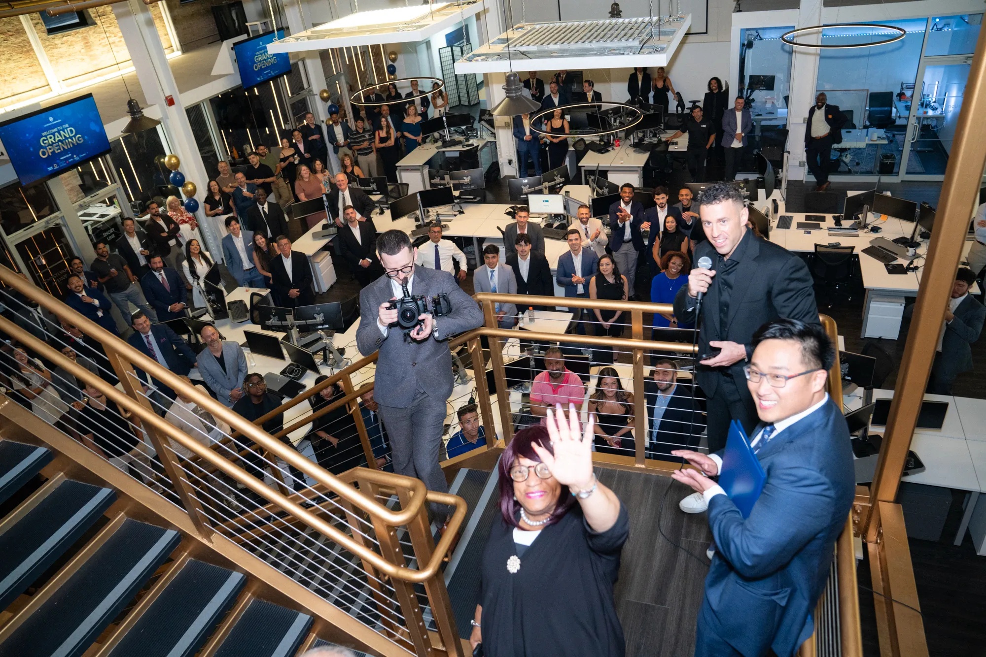 A crowd gathered around the stairs and workstations at Leverage Companies’ office-opening celebration