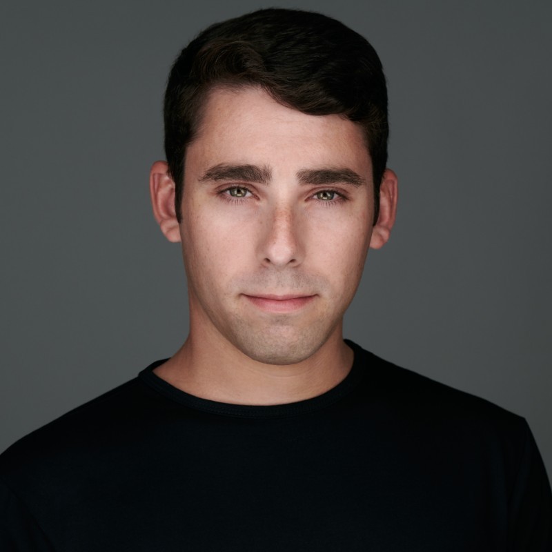 Eric Shoykhet in a black crew-neck shirt against a gray background