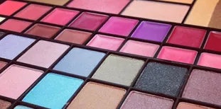 Rows of pink, purple, blue, and neutral shades in a makeup palette
