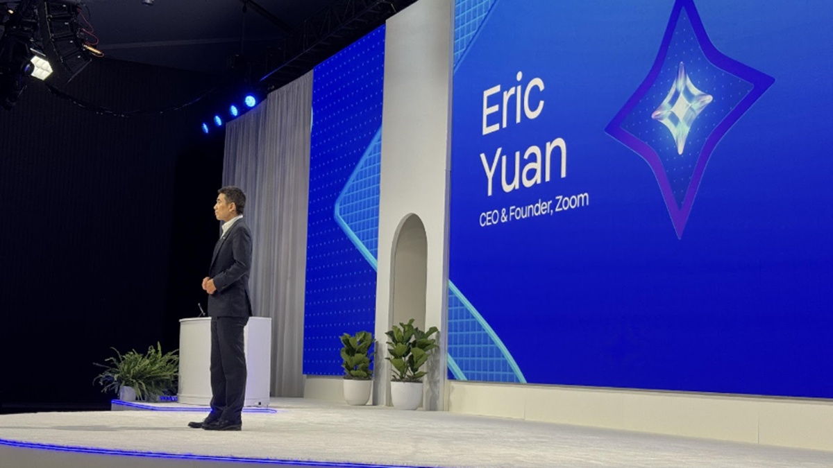 Eric Yuan speaking on a blue-lit Zoomtopia 2024 stage