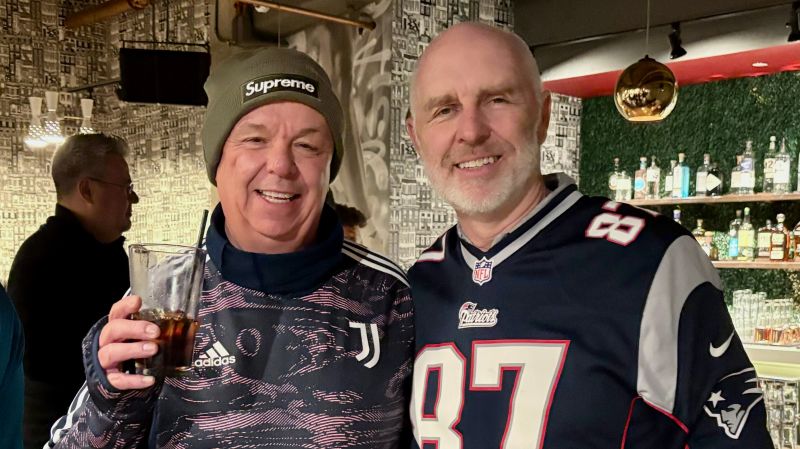 Erik Frieberg, right, wearing a New England Patriots jersey beside Paul Phillips at a MinIO team game night