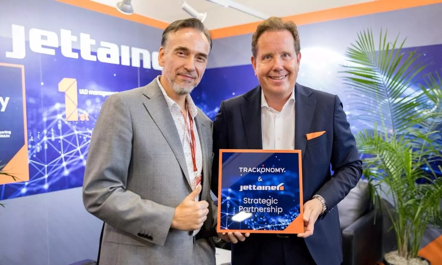 Erik Volkerink, left, and Jettainer CEO Jan-Wilhelm Breithaupt holding a strategic partnership sign in Miami