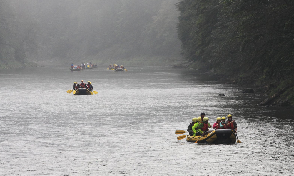 Erlang Solutions colleagues rafting on a wooded river in Poland