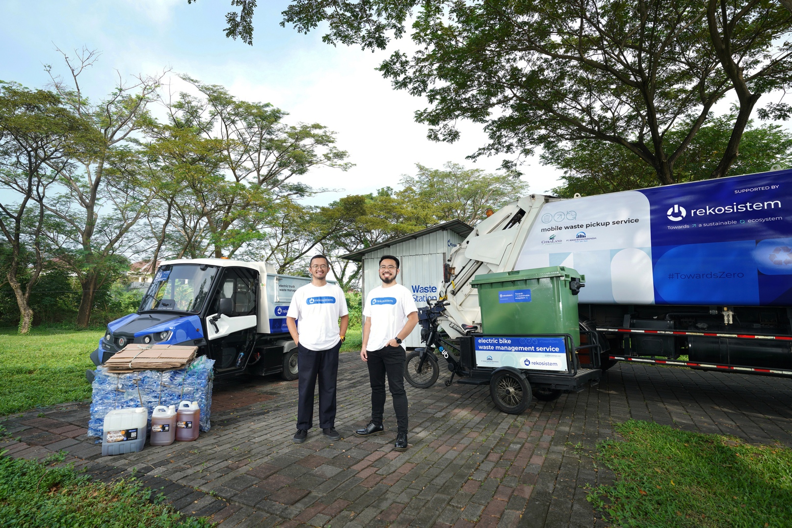 Joshua Valentino on the left and Ernest Layman on the right beside Rekosistem's waste collection vehicles