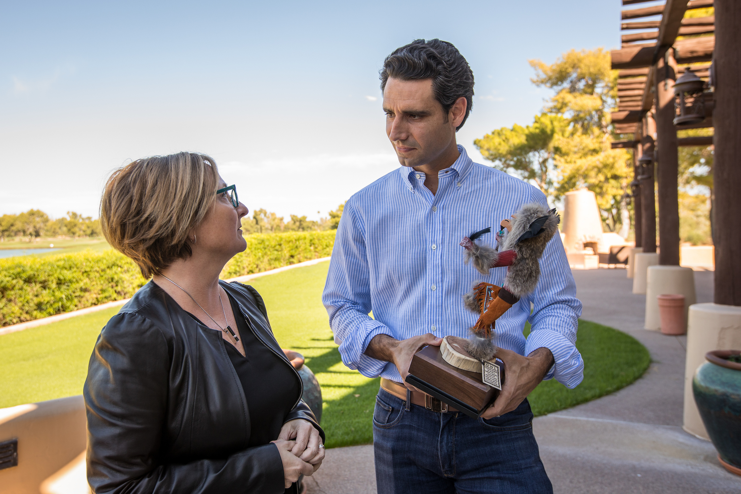 Ernie Garcia receives an owl kachina from ASU business-school dean Amy Hillman.
