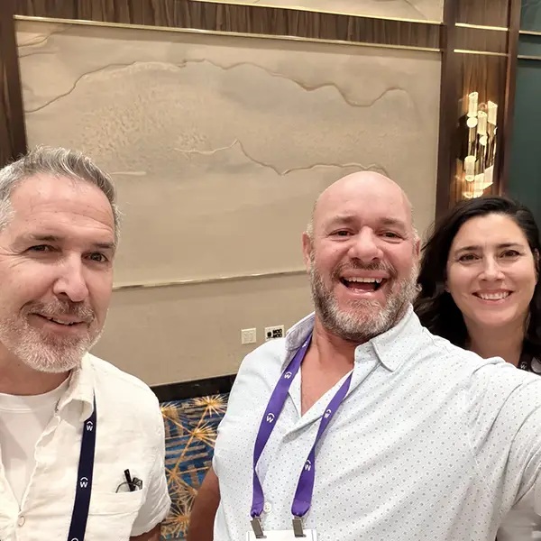 Three attendees smiling together in a photograph ERPA published from Workday DevCon 2026