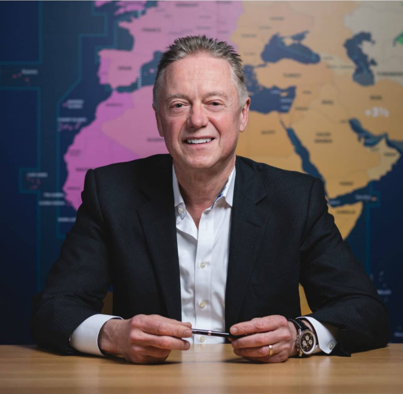An Eseye executive seated in front of a colourful world map