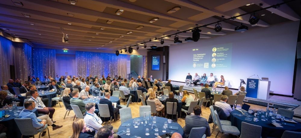 Delegates seated around tables facing an energy industry panel at ESG’s London forum