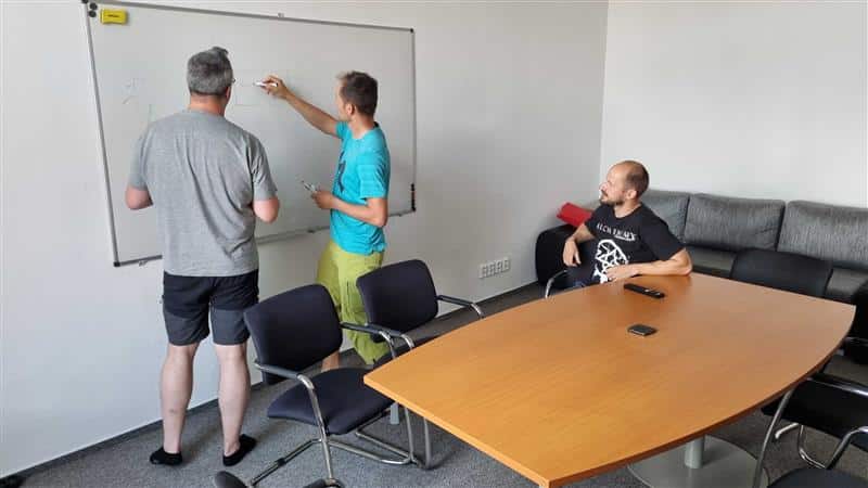 Three ESO colleagues working around a whiteboard and conference table in the Pilsen office