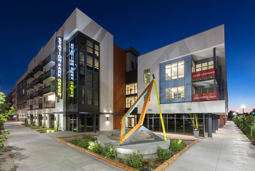 Station Park Green apartments in San Mateo at dusk, with an angular colorful sculpture outside