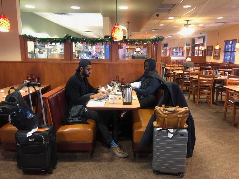 Esusu co-founders Wemimo Abbey and Samir Goel seated together in a cafe