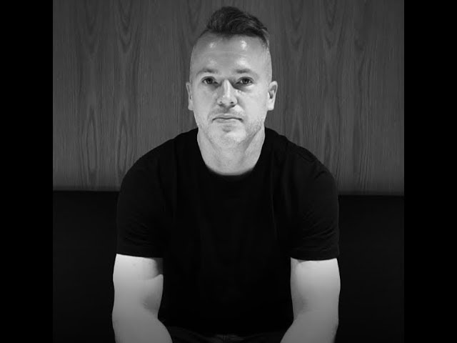 Ethan Dobson seated for an interview, in a black and white photograph