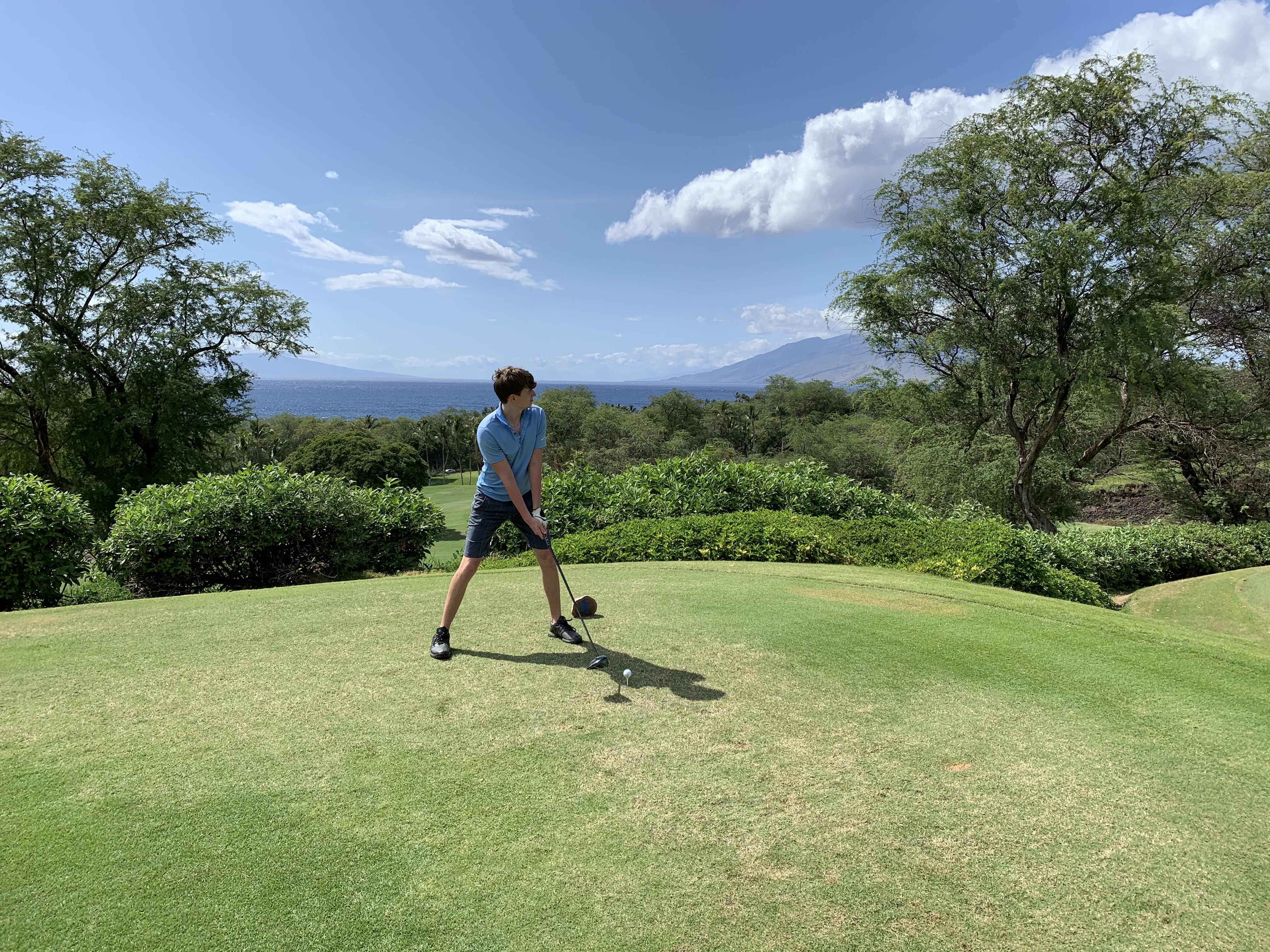Ethan Kinnan preparing to play a golf shot on a coastal course