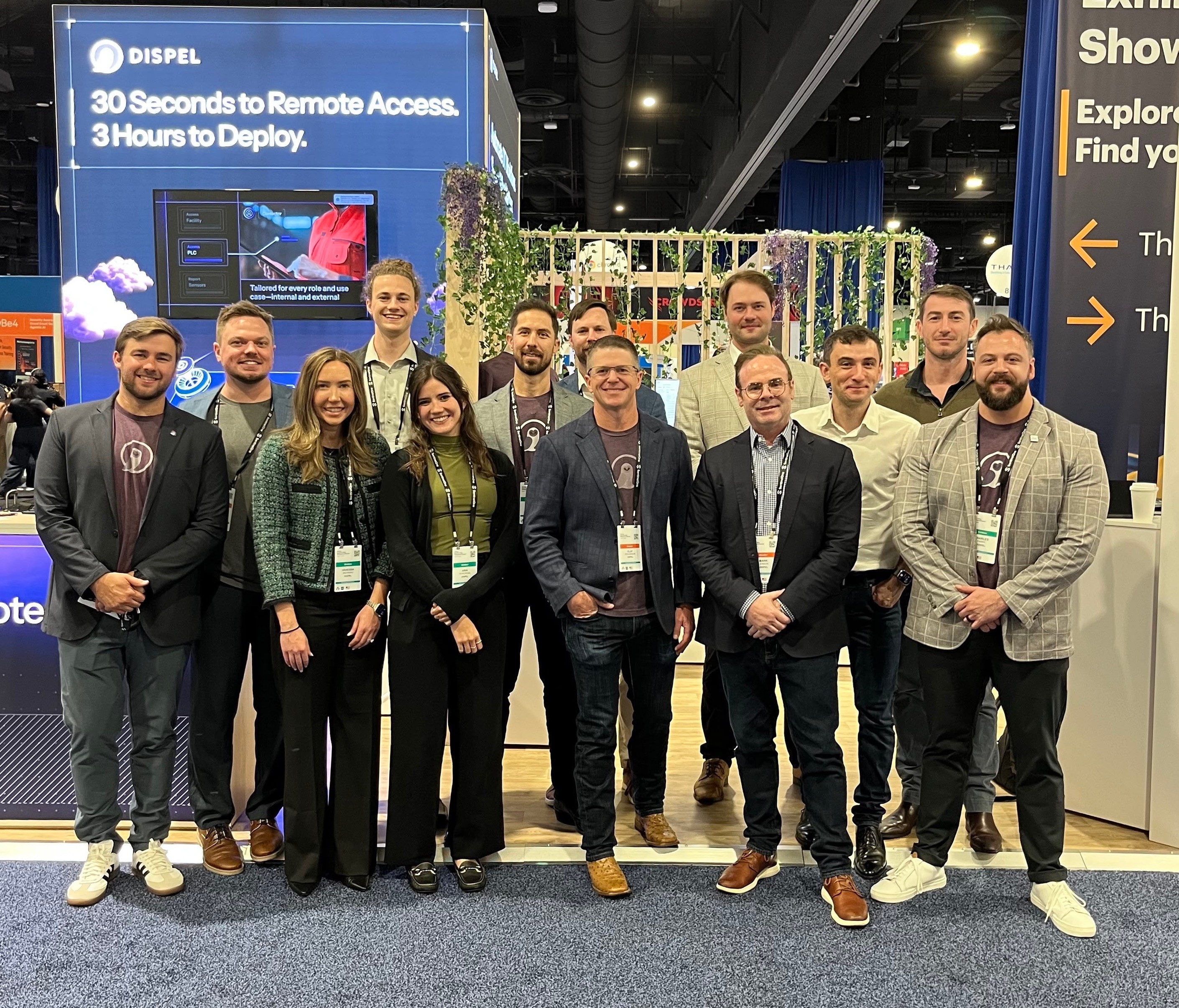 Dispel team members standing together at a blue exhibition booth