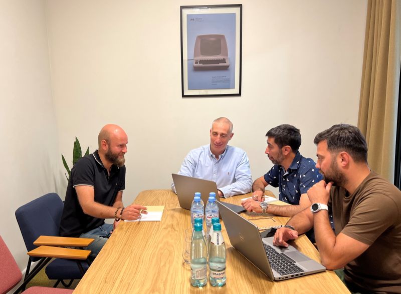 Eugene Goland, second from left, meeting DataArt colleagues around a table in Georgia