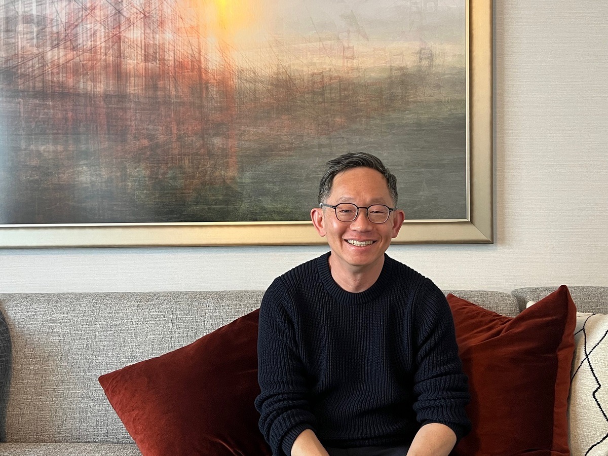 Evan Cheng seated on a sofa, smiling during a GamesBeat interview