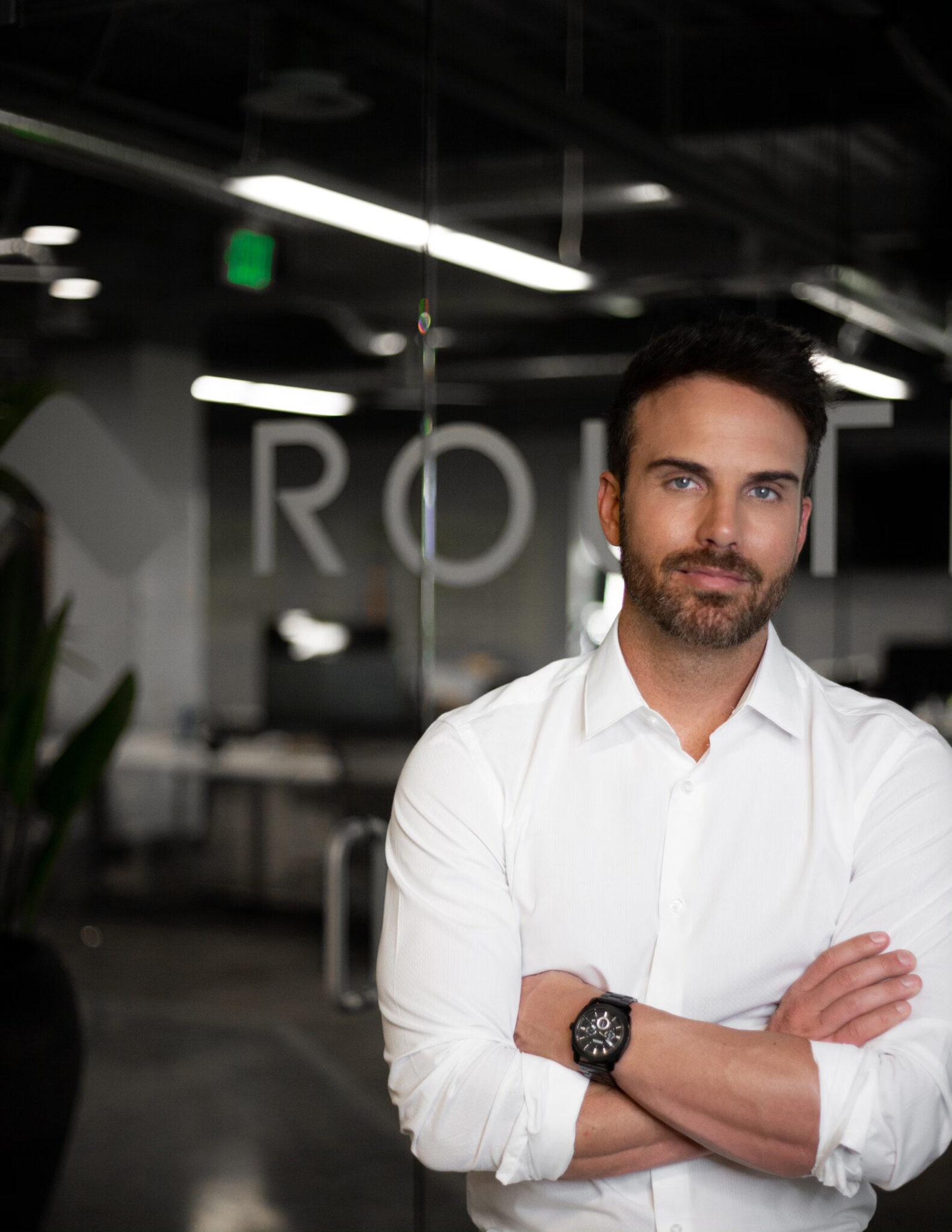Evan Walker standing with folded arms in a Route office