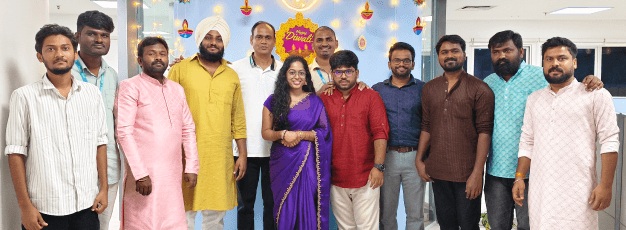 EverestDX colleagues gathered in festive clothes in front of Diwali decorations