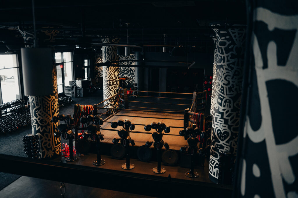 Boxing ring and dumbbell racks at EverybodyFights’ Drydock facility