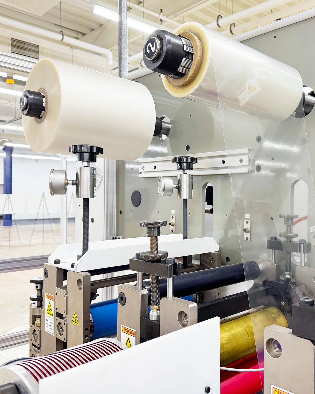 Rolls of membrane material moving through EVOLOH manufacturing equipment