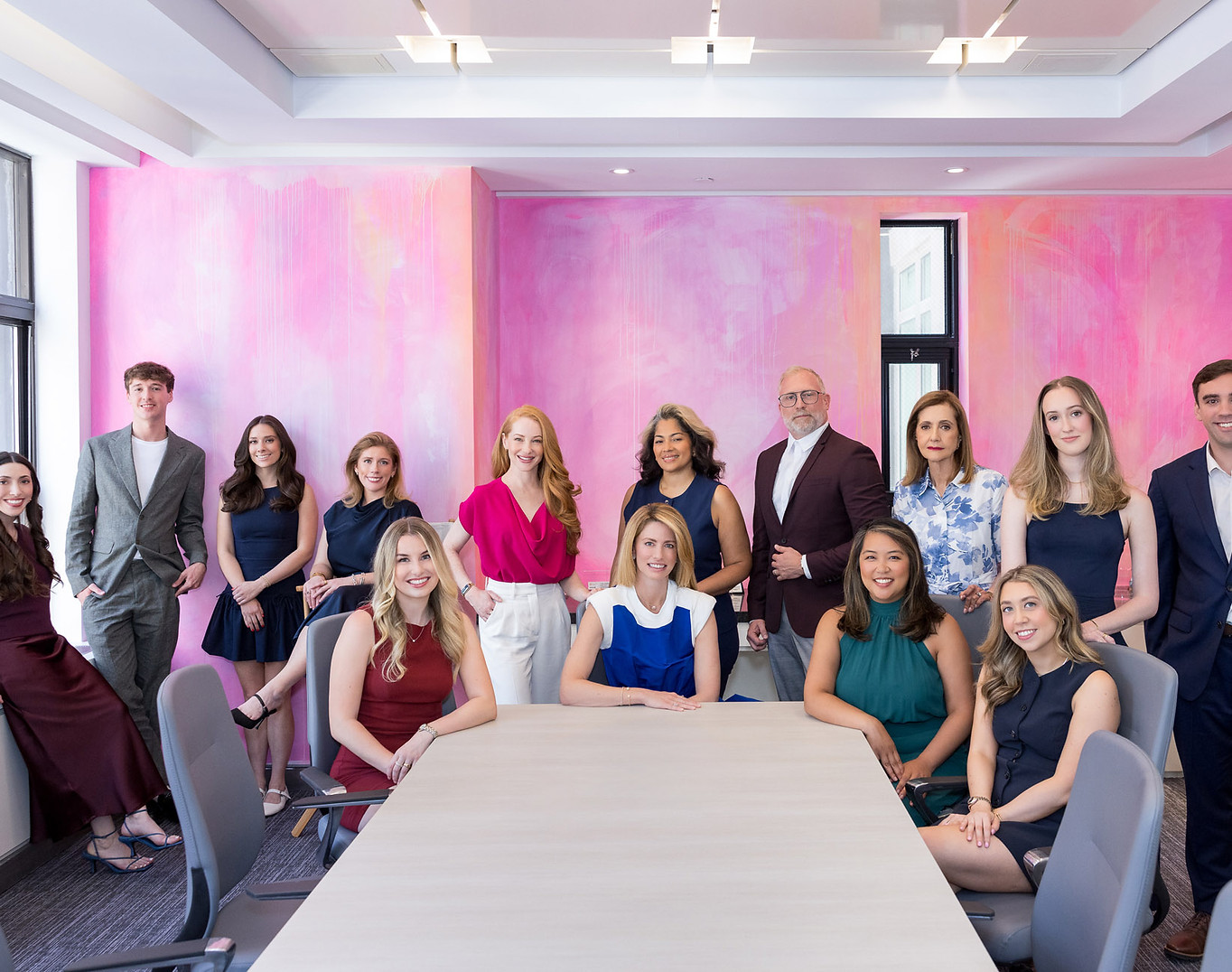 The EvolveMKD team gathered around a conference table in a pink-walled New York office