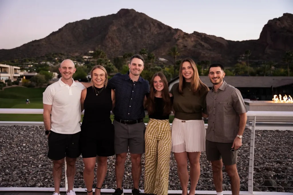 Exit Five team standing together outdoors with mountains behind them