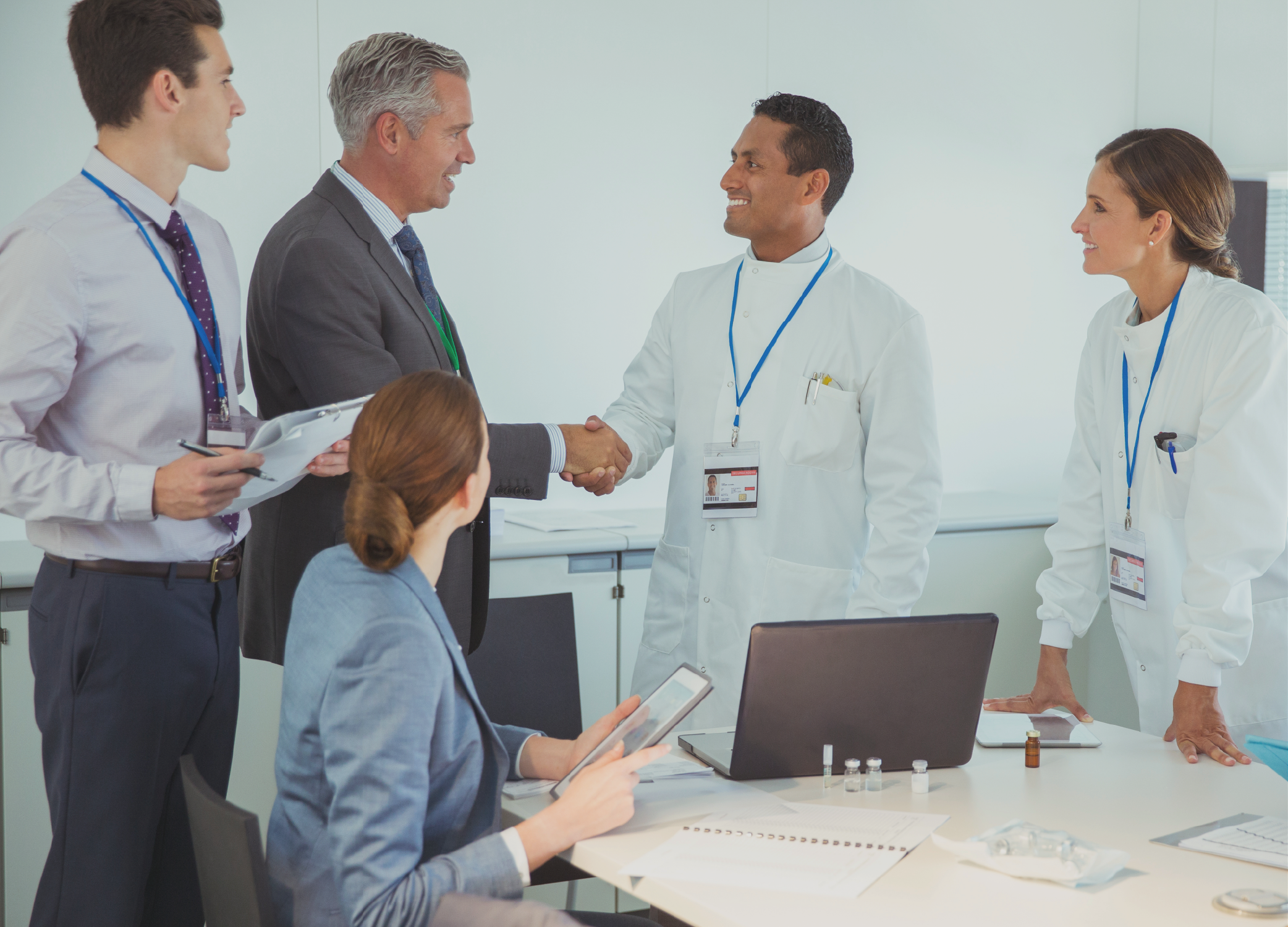 A group discussing work around a table in an illustrative photograph on Exostar's SAM product page