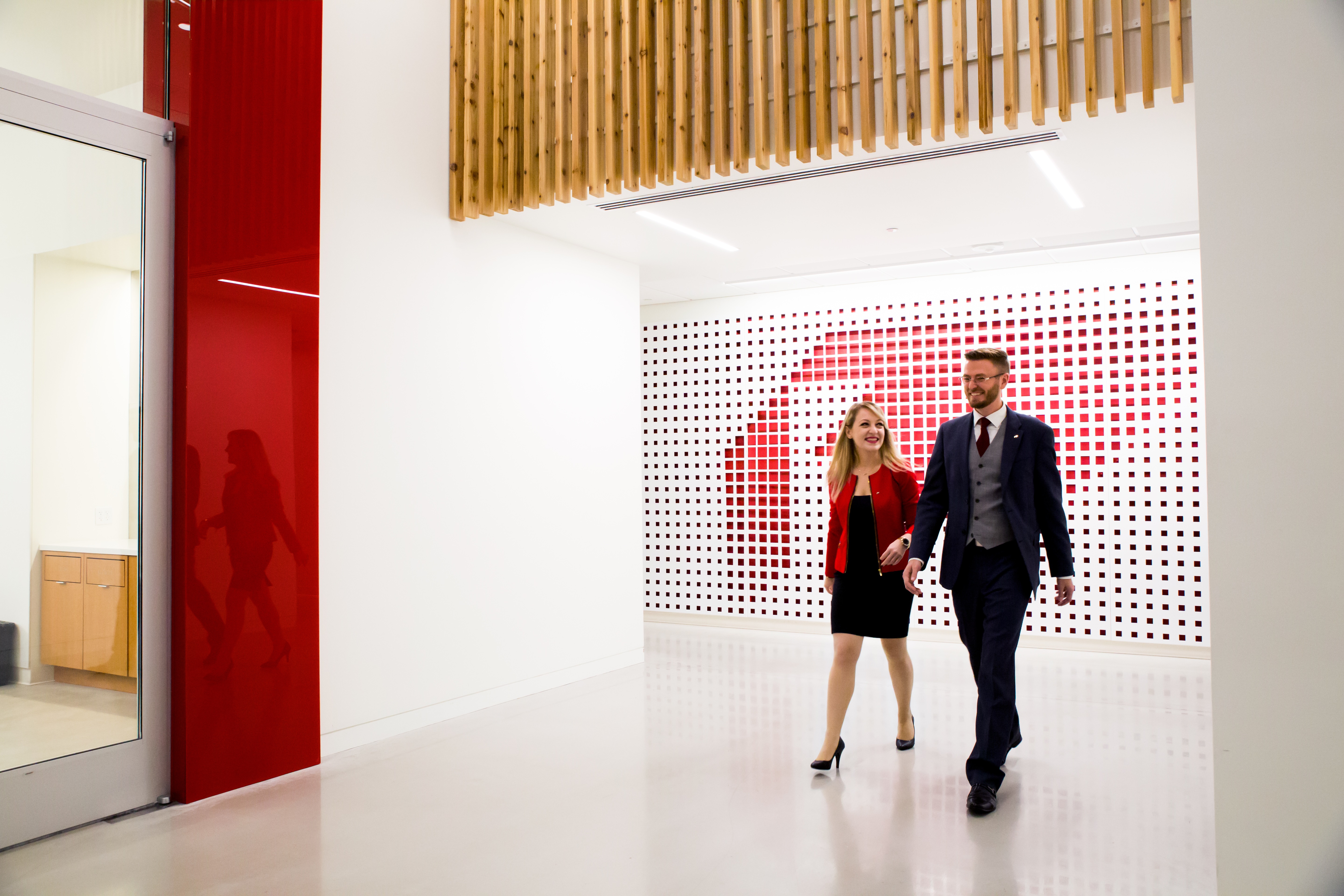 Two professionally dressed people walking through an Expeditors office interior