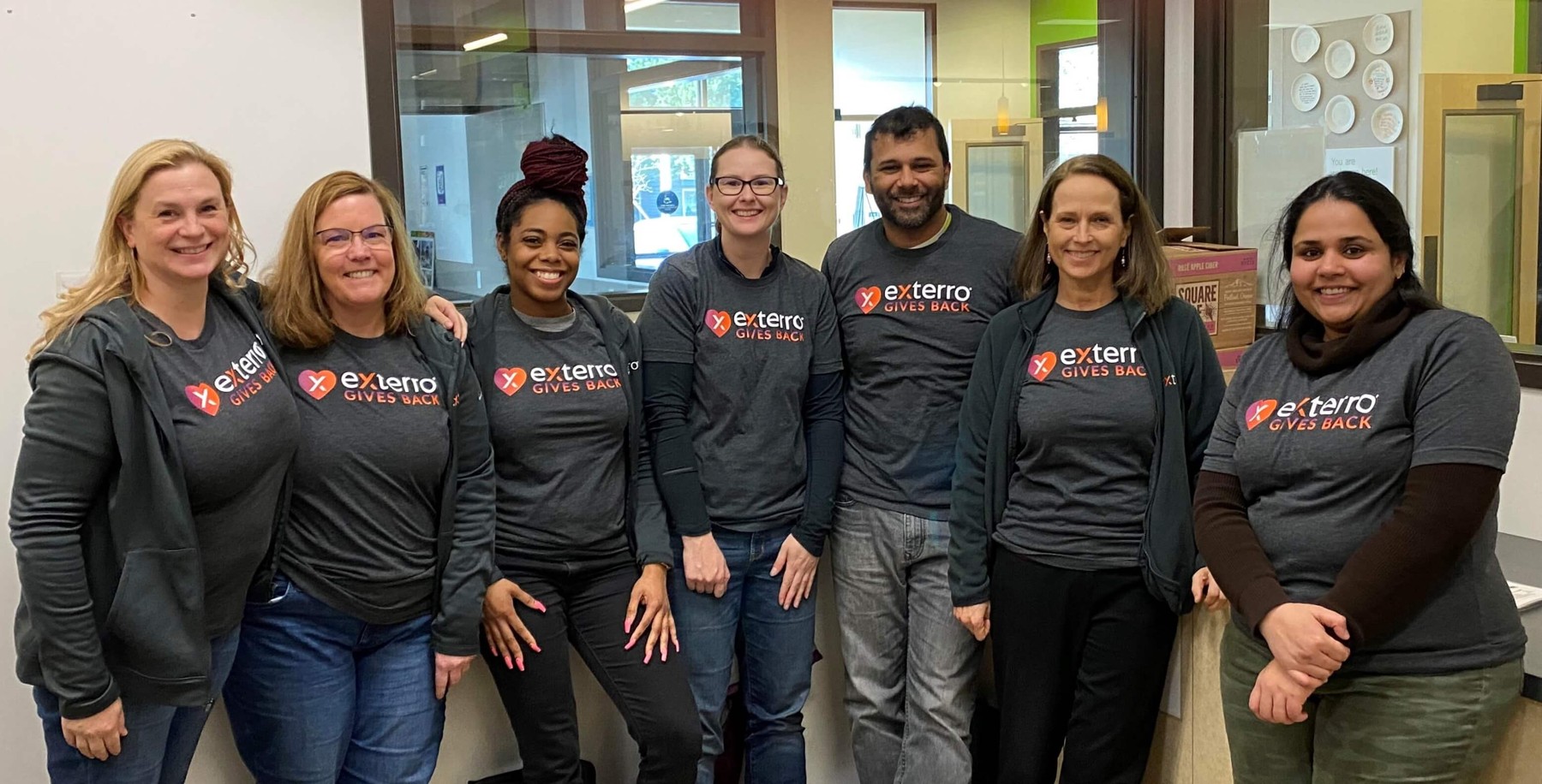 Seven members of the Exterro team wearing Exterro Gives Back shirts