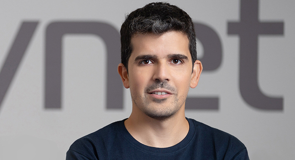 Eyal Gruner wearing a Cynet T-shirt in front of the company name
