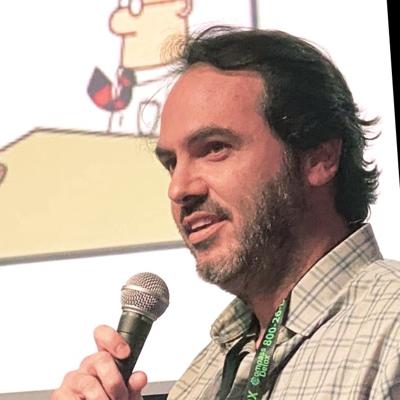 Fabio Torelli speaking into a handheld microphone at an event