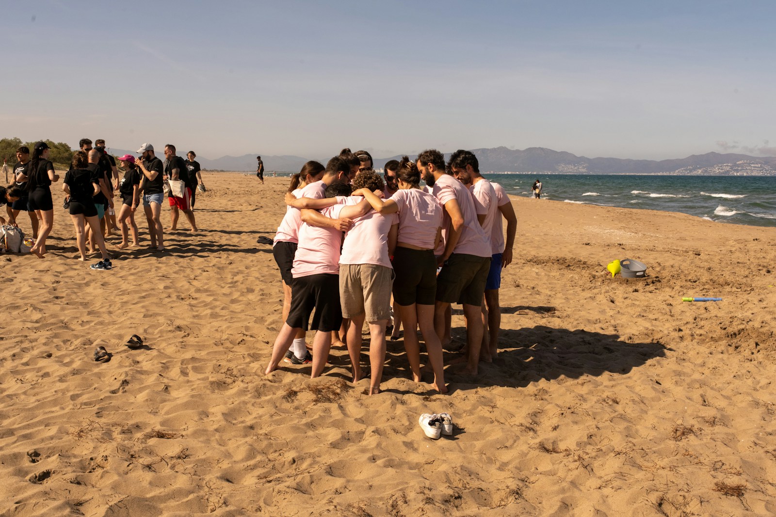 Factorial colleagues gathered in a huddle on a beach