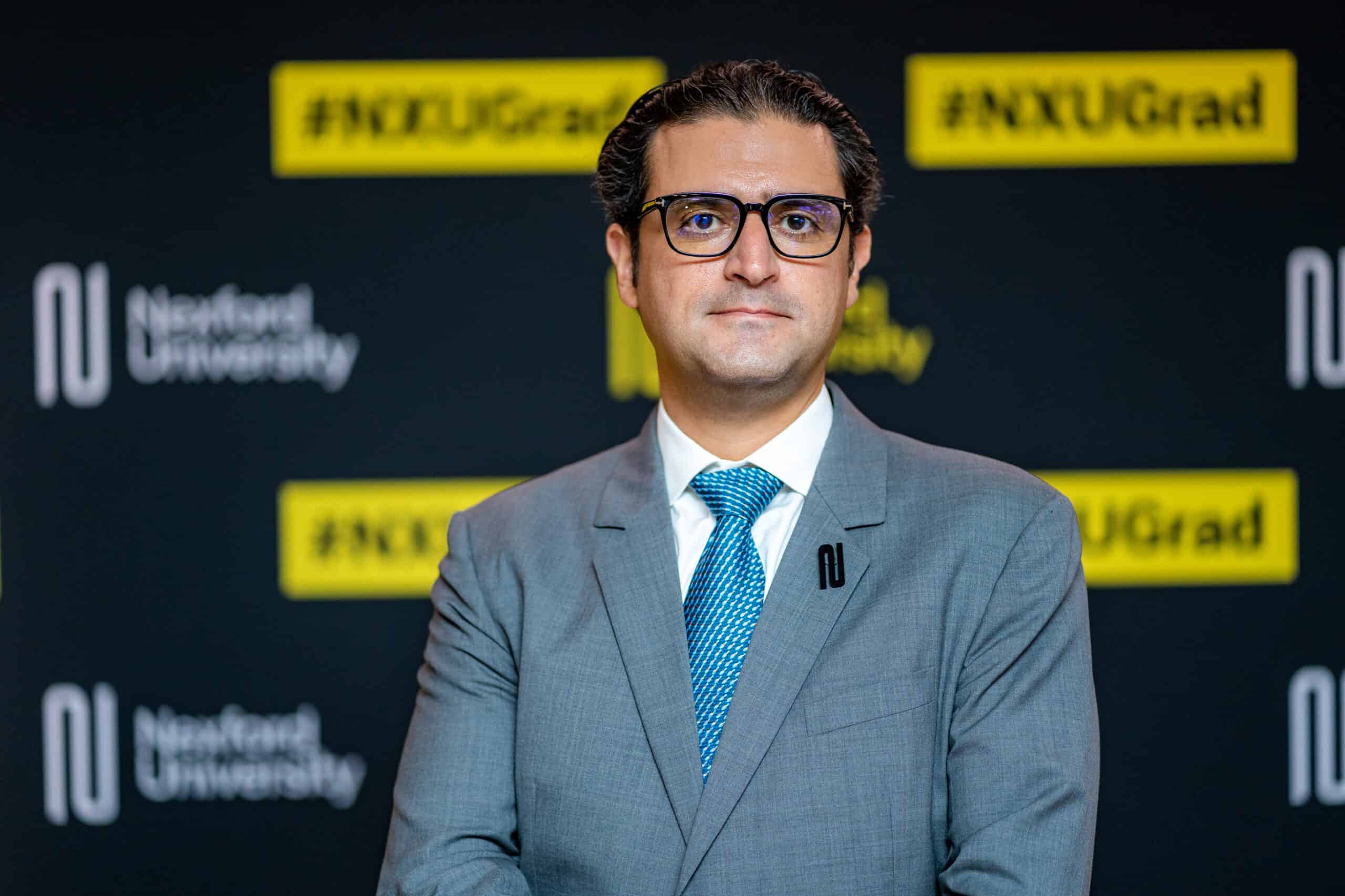 Fadl Al Tarzi in front of a Nexford University graduation backdrop