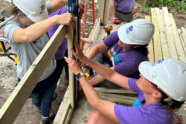 F&G employees wearing hard hats while volunteering on a construction project