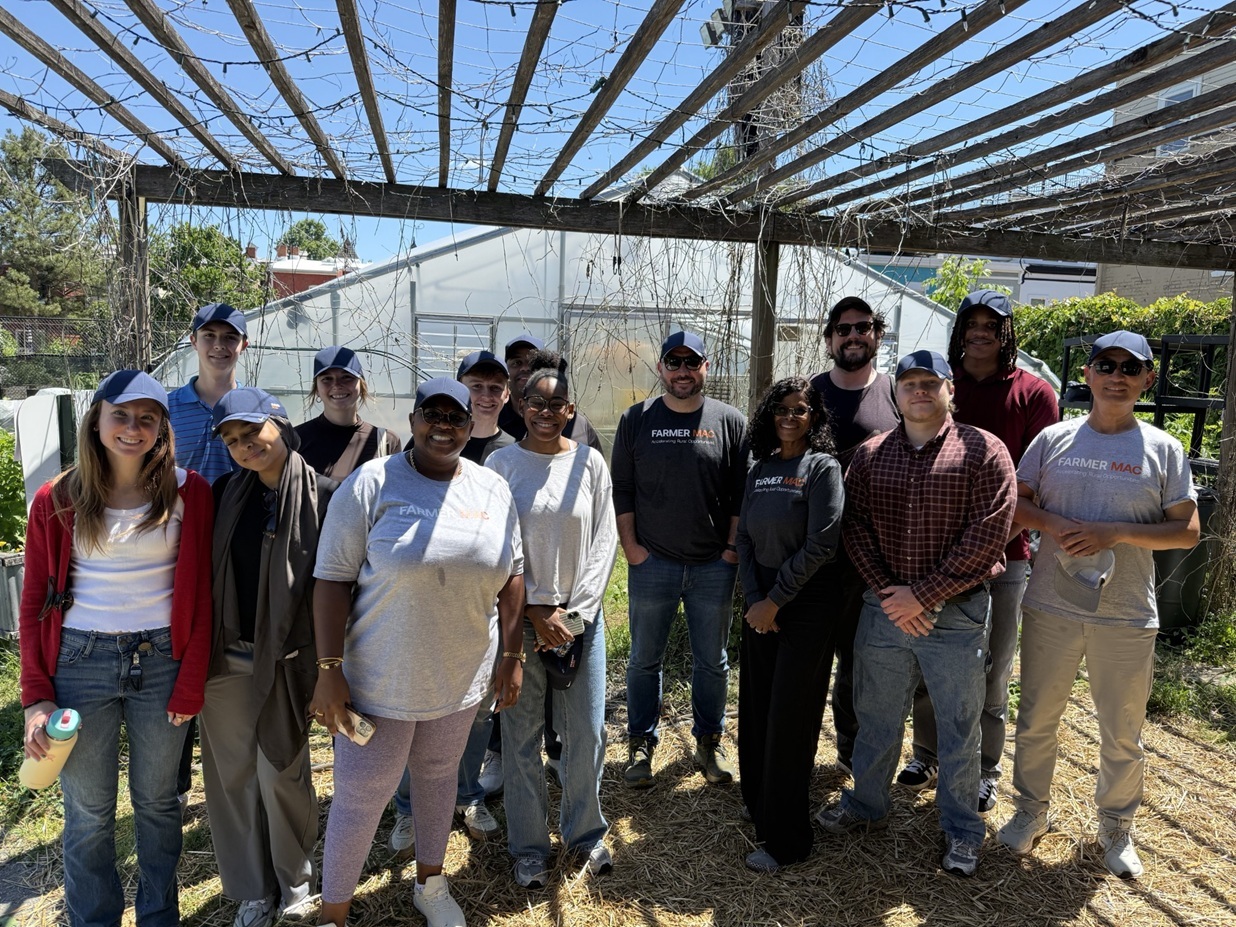 Farmer Mac volunteers gathered beneath a garden trellis