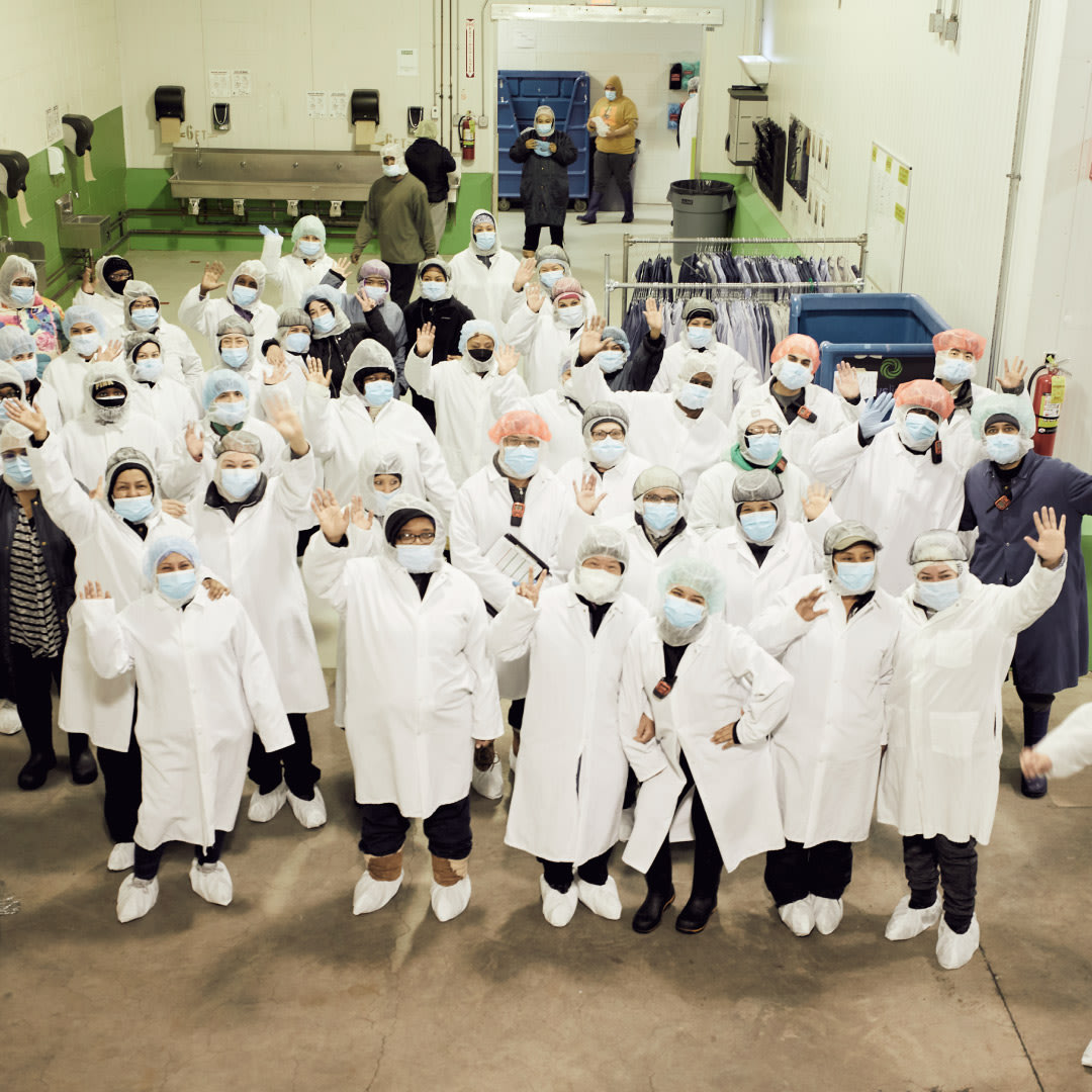Farmer’s Fridge kitchen employees wave from the production floor