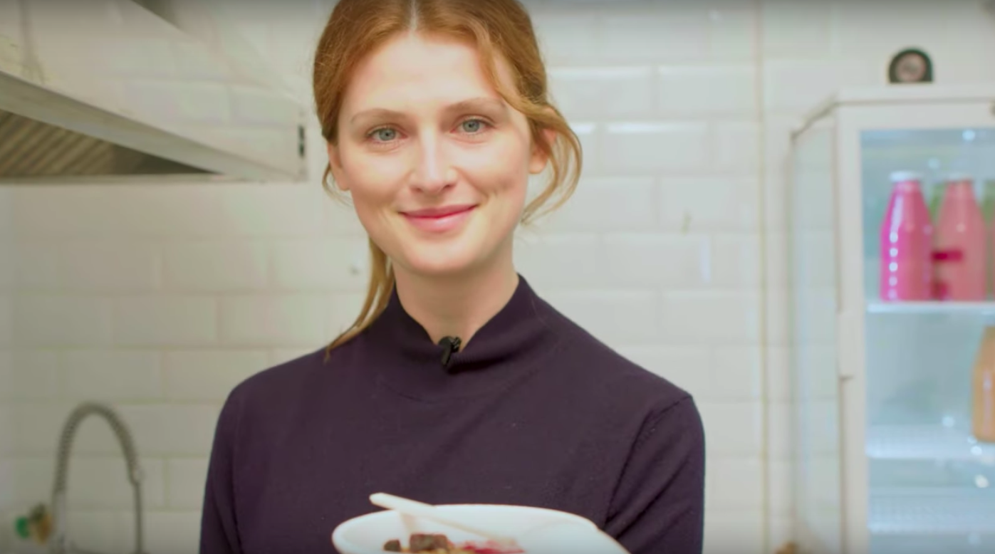 A woman holding a bowl in a bright kitchen, in a still used for FashionOne’s Eco Trendsetters programme