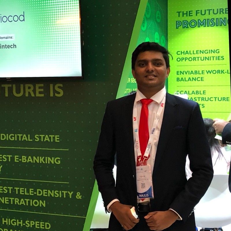Fasil KK in a suit beside a green IOCOD presentation display
