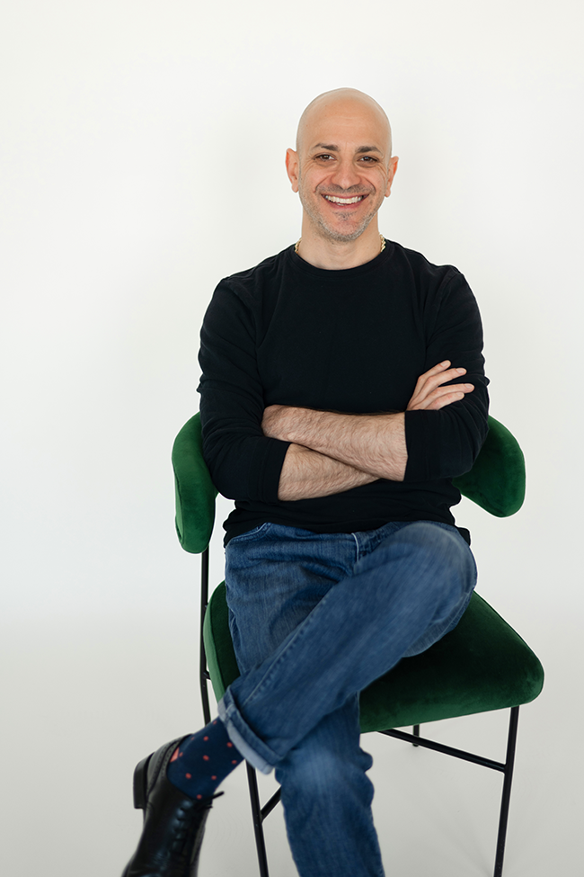 Michal Fasone seated in a green chair