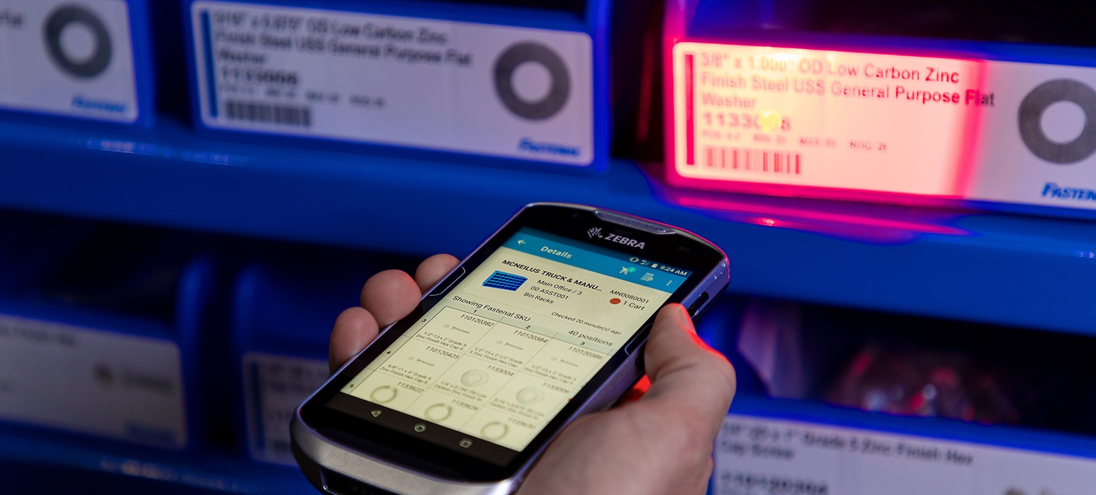 A handheld scanner reads a labelled parts bin in Fastenal’s inventory system