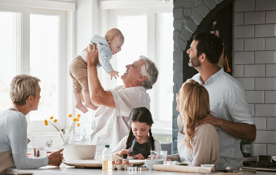 A multigenerational family gathered in a bright kitchen